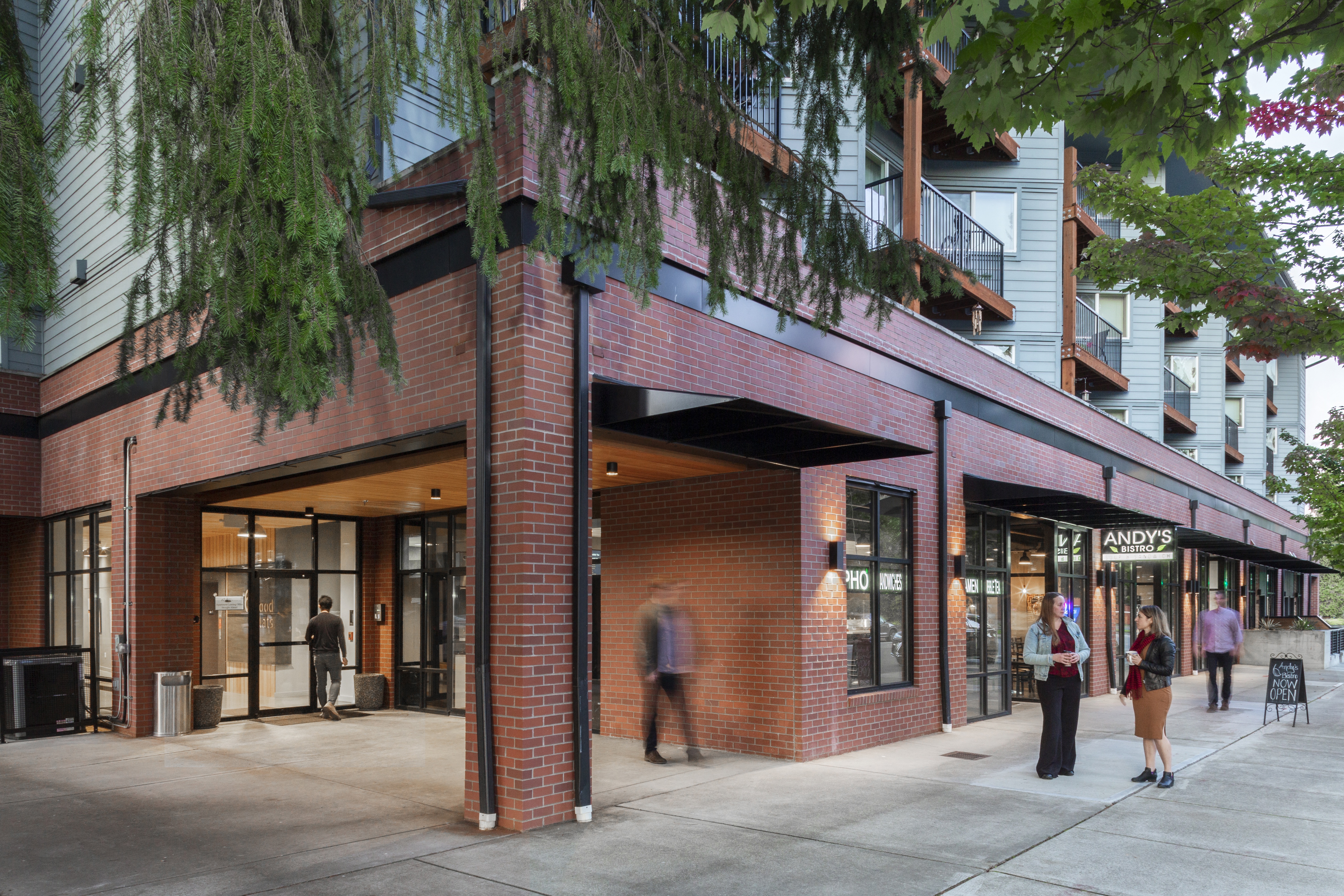 a red brick building with people walking in front of it